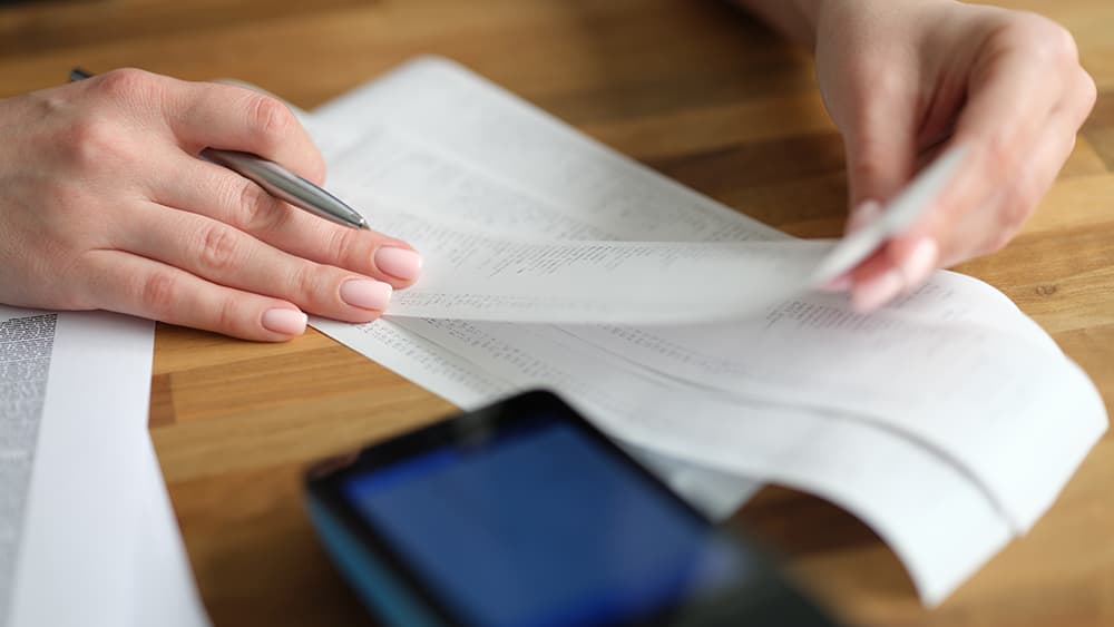 Woman reviewing charges on receipts for her business